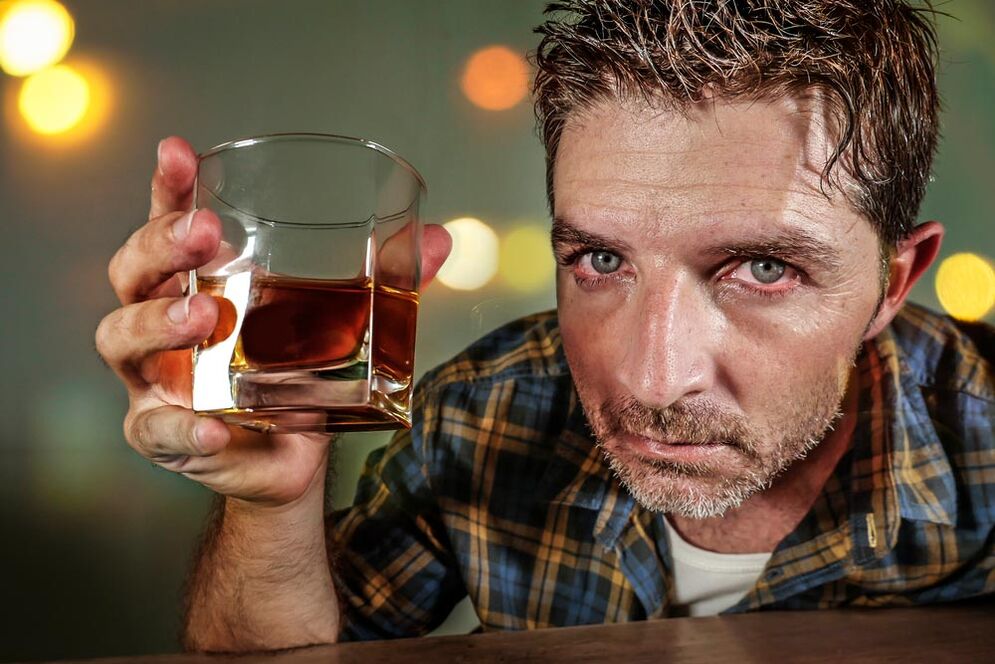 Een man alcoholist ziet er pijnlijk uit